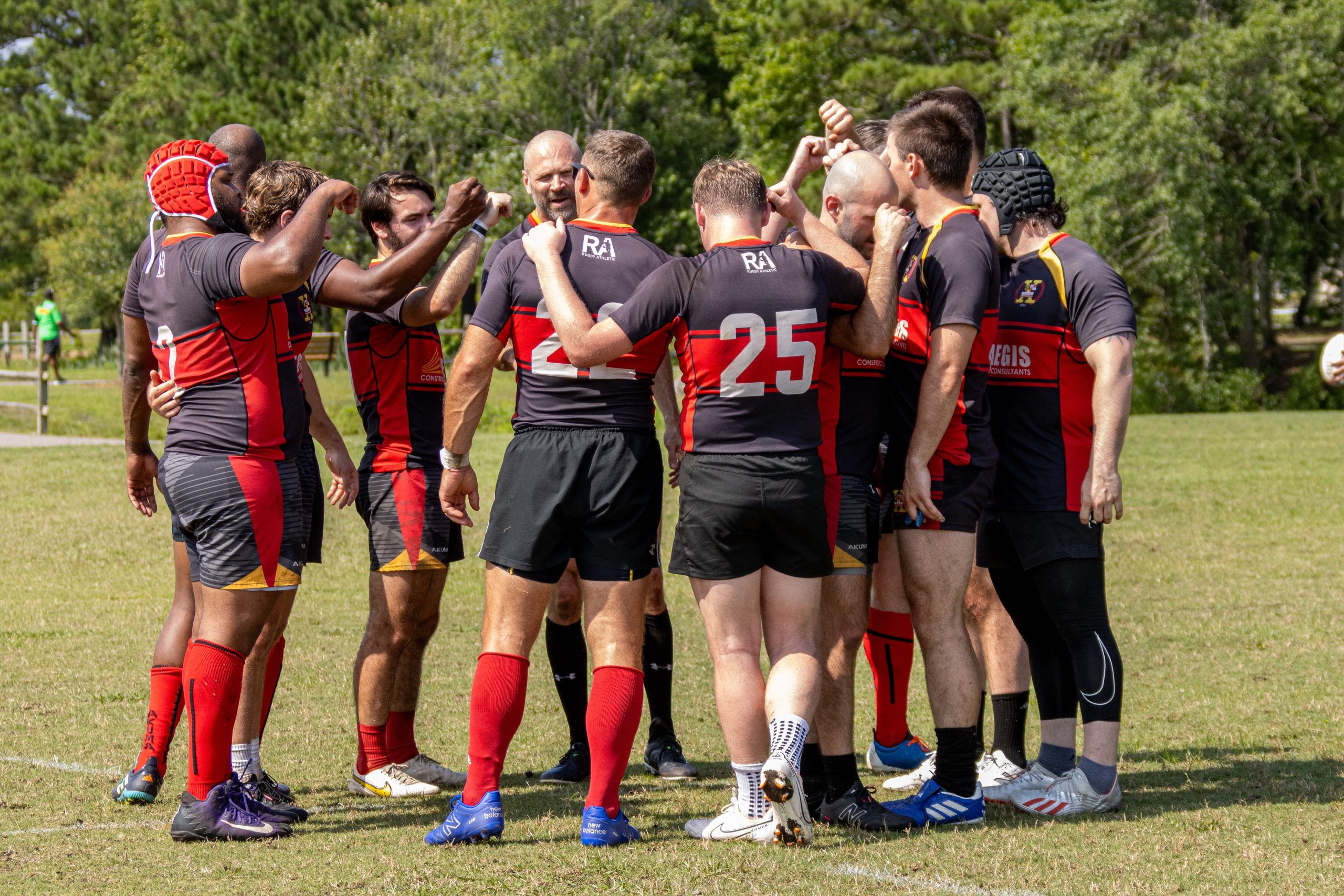 Rugby team huddled on the field post game to conclude the match.
